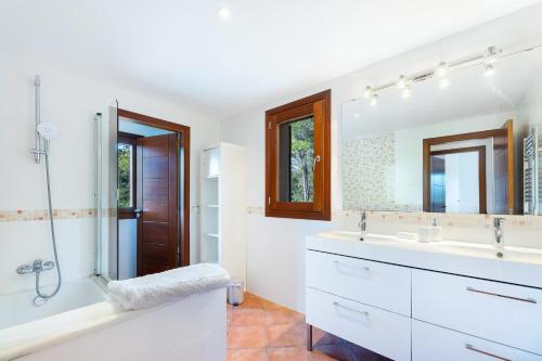 uma casa de banho branca com um chuveiro e um lavatório. em Villa Jacelia em Sa Pobla