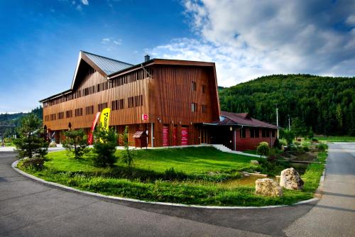 a large building on a grassy area next to a road at Apartmány Humno in Stará Turá