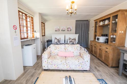 een slaapkamer met een bed en een bank bij The Paper Fig House in Plettenbergbaai