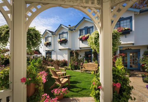 an archway leading to a garden with flowers at Mill Rose Inn in Half Moon Bay