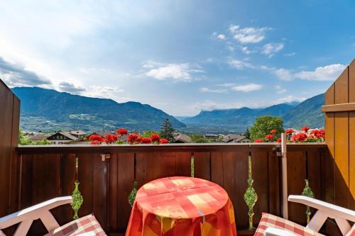 a balcony with a table and chairs and a view of mountains at Wiesengrund - Wohnung 5 in Tirolo