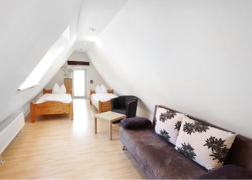 a living room with a couch and a chair at Restaurant-Café-Pension Himmel in Landshut