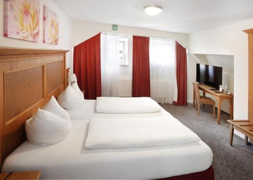 a hotel room with two beds and a desk at Restaurant-Café-Pension Himmel in Landshut