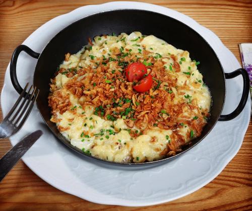 a pan filled with food on a white plate at Restaurant-Café-Pension Himmel in Landshut