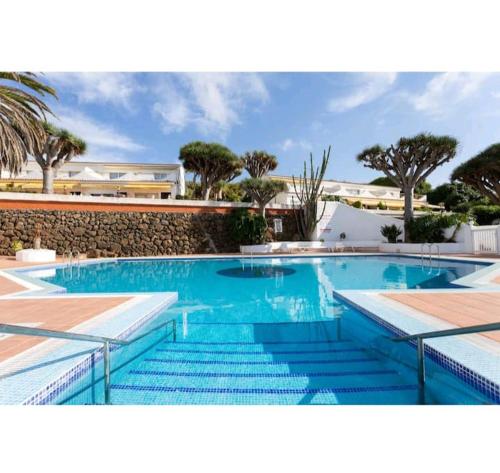 uma grande piscina com água azul e escadas em Guanche Bay em Santa Cruz de Tenerife