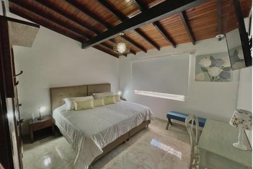 a bedroom with a bed and a wooden ceiling at Hotel Casa Sonata in Medellín