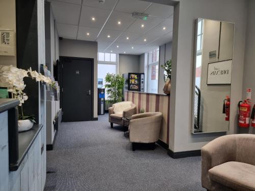 a salon with a waiting room with chairs and a mirror at Escape Hotel in Barrow in Furness