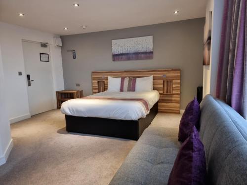 a bedroom with a bed and a couch at Escape Hotel in Barrow in Furness