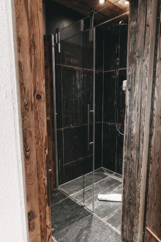a bathroom with a shower with a glass door at Jufenalm BOHO & Wellnesshotel in Maria Alm am Steinernen Meer