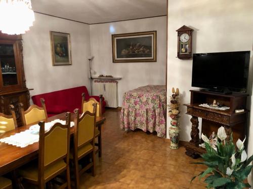 a living room with a dining table and a television at La Casa in Cerea