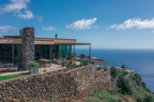 a house on top of a stone wall at The Rock Villas in Estreito da Calheta
