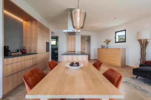 a kitchen and dining room with a wooden table and chairs at The Rock Villas in Estreito da Calheta