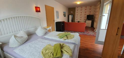 a bedroom with two beds and a living room at Pension Lenz in Sassnitz