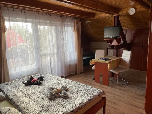 a bedroom with a bed and a desk and a television at Fehérló Vendégház & Restaurant in Bük