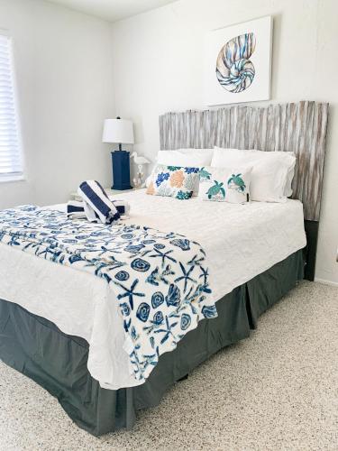 a bedroom with a large bed with blue and white sheets and pillows at Ocean Eleven Suites in New Smyrna Beach