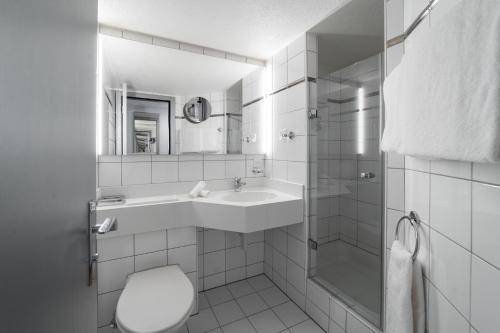 a bathroom with a sink and a toilet and a shower at Boutique Hotel Stockalperhof in Brig