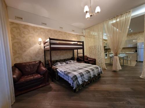 a bedroom with a bed and a chair at Arcadia Apartments in Odesa