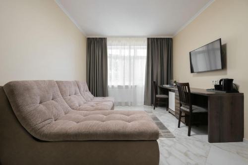 a living room with a couch and a desk at Borys Hotel Boryspil Airport in Boryspilʼ