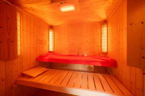 a sauna with a red bed in a wooden room at TUUS in Dishoek in Dishoek