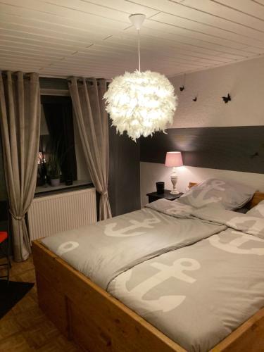 a bedroom with a large bed with a chandelier at Stal-escapade in Großlangenfeld