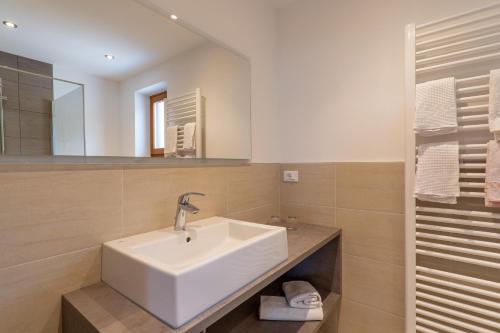 a bathroom with a white sink and a mirror at Wiesengrund - Wohnung 1 in Tirolo