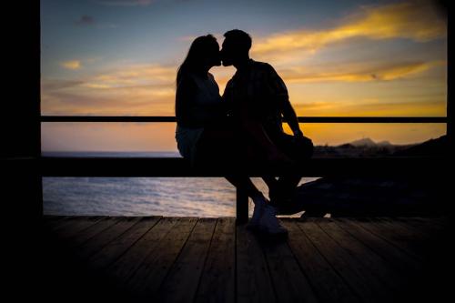 a man and a woman sitting on a bench kissing at Curacao Avila Beach Hotel in Willemstad
