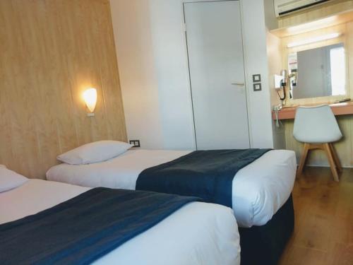 
a hotel room with two beds and two lamps at Fasthotel Perpignan in Perpignan

