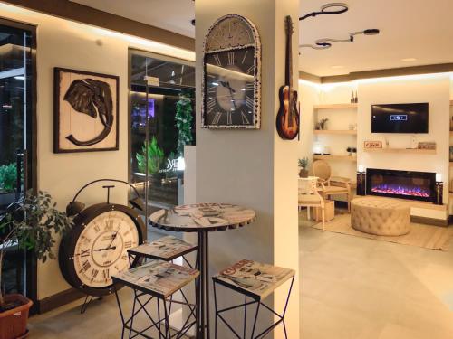 L'opera Deluxe Hotel في أكشاي: غرفة بها ساعة وطاولة وكراسي