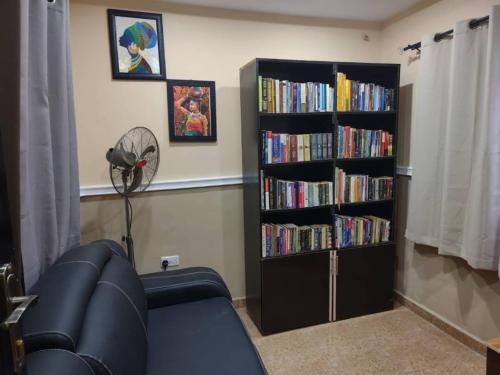 una sala de estar con sofá y una estantería llena de libros. en The Edgewood Manor, Entire Service apartment with 24 hours power, en Akure