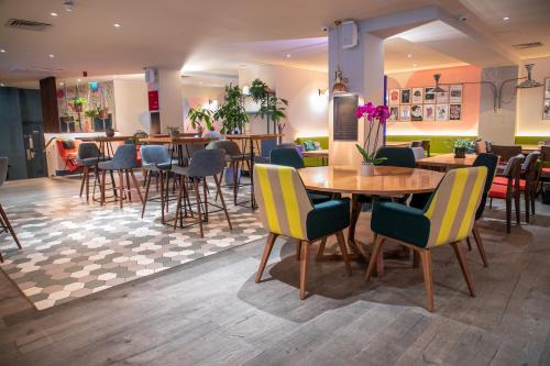 a restaurant with tables and chairs in a room at The Corner London City in London