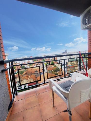 a balcony with chairs and a view of a city at Apartment 31 in Pristina