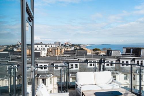 a balcony with white chairs and a view of the city at Westcliff Penthouse in Bournemouth