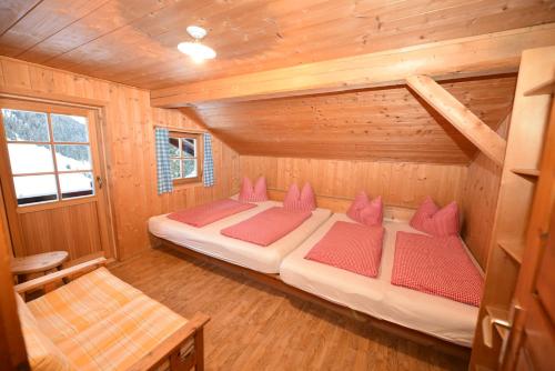 sypialnia z 2 łóżkami w drewnianym domku w obiekcie Gallfallalm w mieście Santa Maddalena in Casies Valbassa