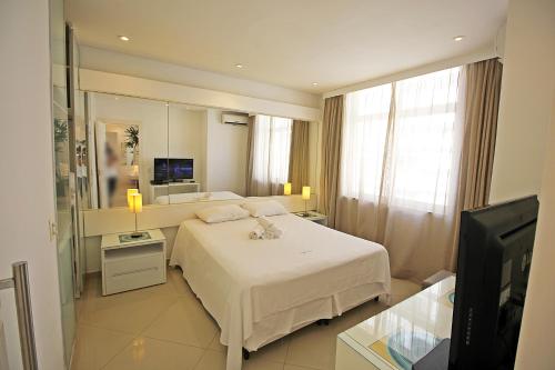 - une chambre avec un lit blanc et une télévision dans l'établissement Rio Spot Homes D041A, à Rio de Janeiro