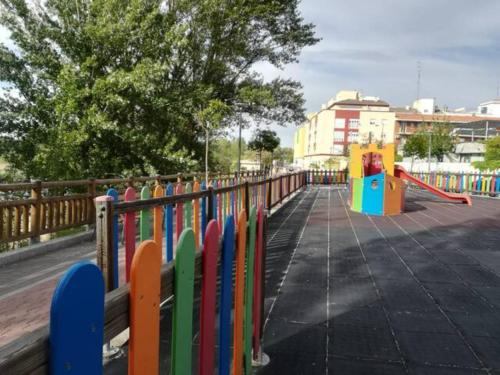 a colorful fence in a park with a playground at EL DESVÁN in Santa Marta de Tormes