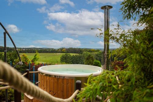a jacuzzi tub in a garden with a view at Ferienhaus Blockhaus am Hengstberg bei Dresden in Bannewitz