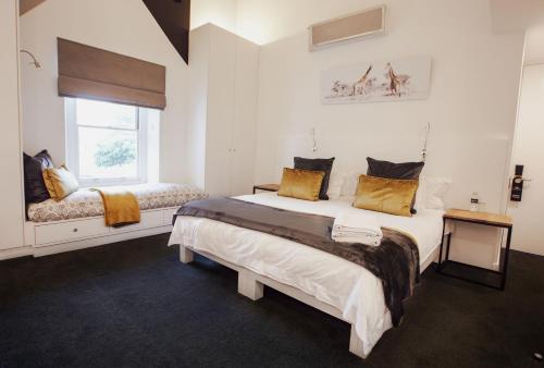 a bedroom with two beds and a window at Boschenmeer House in Paarl