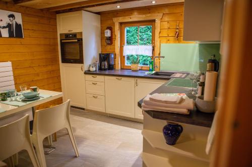 a kitchen with white cabinets and a counter top at Ferienhaus Blockhaus am Hengstberg bei Dresden in Bannewitz