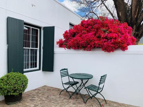 a garden area with a table and chairs at de Wingerd B & B in Graaff-Reinet