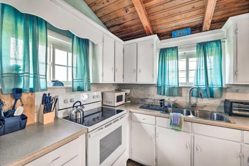 a kitchen with white cabinets and blue curtains at Pet-Friendly Townhome, 2 Blocks to Atlantic Beach! in Atlantic Beach