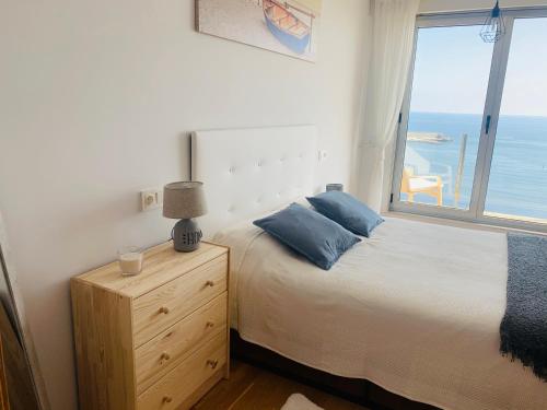 a bedroom with a bed and a window with the ocean at Apartamentos LAMAROSA - DELUX -PARKING- in Burela de Cabo