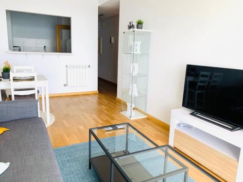 a living room with a tv and a glass table at Apartamentos LAMAROSA - DELUX -PARKING- in Burela de Cabo