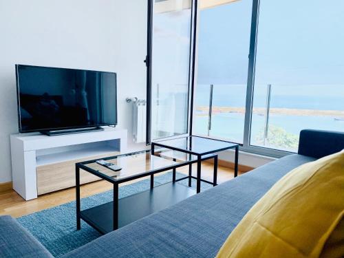 a living room with a tv and a couch at Apartamentos LAMAROSA - DELUX -PARKING- in Burela de Cabo