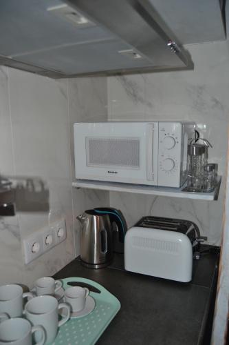 un bancone della cucina con tazze e forno a microonde di Suite Estudio Montaña a Torremolinos