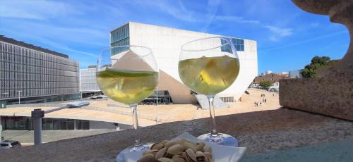 dos vasos de vino blanco sentados en una cornisa en Boavista Class Inn, en Oporto