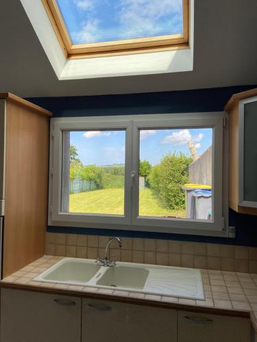 uma cozinha com um lavatório e uma janela em Maison de village avec jardin 15mn des plages, wifi, 2 chambres, jardin em Hesdin-lʼAbbé