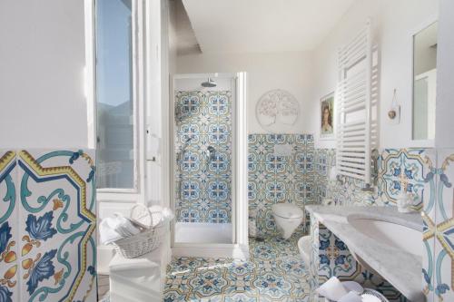 ein Badezimmer mit blauen und weißen Fliesen und einer Badewanne in der Unterkunft Caluga House in Piano di Sorrento