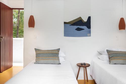 two beds in a room with white walls at Miradouro de São Sebastião in São Sebastião