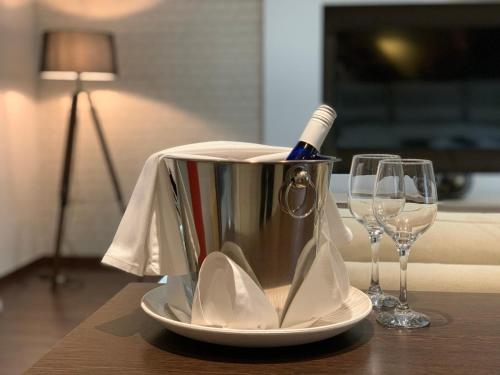a silver ice bucket with a toothbrush in it next to two glasses at Budapest Downtown in Style - Luxury Apartment in Budapest