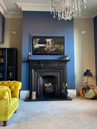 a living room with a television and a fireplace at Newgate House in Morpeth